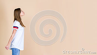 Profile of charming young adult woman waiting kiss standing isolated on pastel beige background Stock Photo