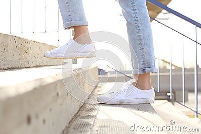 Profile of woman legs wearing sneakers walking up stairs Stock Photo