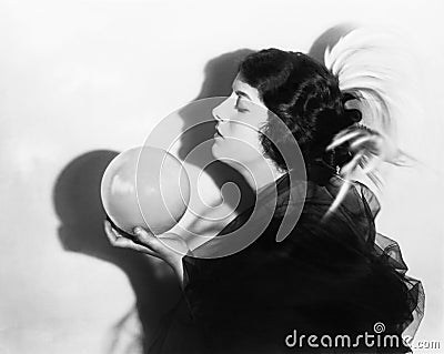 Profile of dramatic woman holding sphere Stock Photo