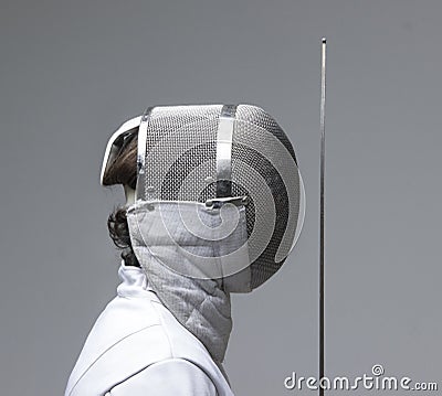 Profile of a fencer in fencing mask with the sword.Studio shot Stock Photo