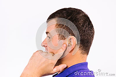 Profile photo of a deaf man with a hearing aid device in ear on a white background. Enlarged photo. Stock Photo