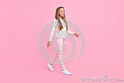 Profile photo of positive nice carefree small lady walk wear dotted shirt pants footwear pink color background Stock Photo