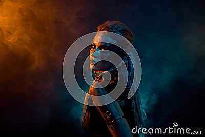 Profile photo of terrifying valkyrie pagan woman scary glance orange blue color lights isolated on dark background Stock Photo
