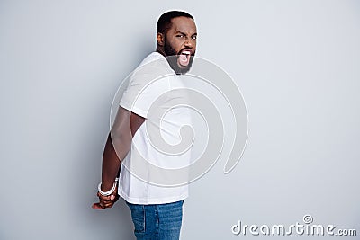 Profile photo of yelling crazy dark skin african guy antiracism group leader showing tied with rope arms police took his Stock Photo