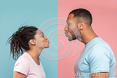 Profile photo of young black spouses reaching to each other and trying to kiss, isolated over pink and blue background Stock Photo