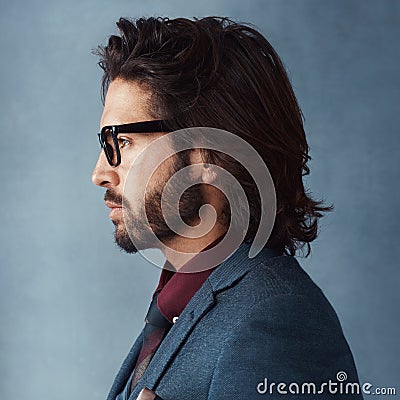 Profile on point. Studio shot of a handsome and dapper young man posing against a grey background. Stock Photo