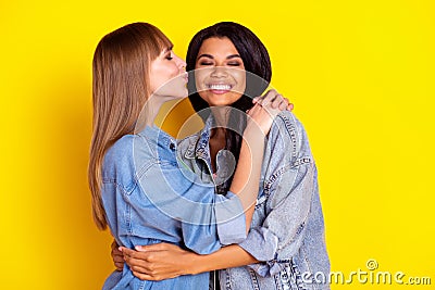 Profile portrait of charming lovely ladies hugging kiss cheek closed eyes isolated on yellow color background Stock Photo