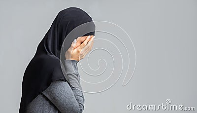 Profile portrait of crying muslim woman covering her face with hands Stock Photo