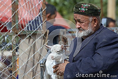 Profile portrait of old man with young goat, Sunday Livestock Ma Editorial Stock Photo