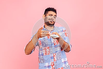 Profile portrait of self confident young adult handsome man with beard scattering dollars with proud facial expression, rich Stock Photo