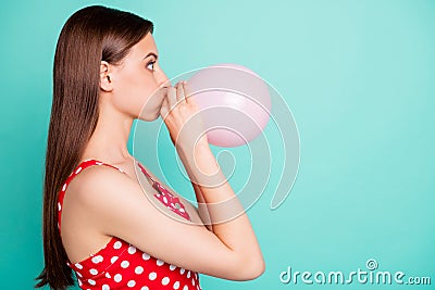 Profile side photo of astonished girl inflating balon looking wondering wearing polka dot dress singlet isolated over Stock Photo