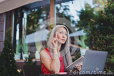 Profile side photo of mature attractive asian woman freelancer serious think writer laptop plan restaurant outdoors Stock Photo