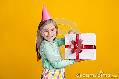 Profile side photo of young small girl happy positive smile receive present box isolated over yellow color background Stock Photo