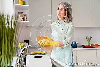 Profile side view portrait of attractive bored grey-haired woman doing dishes neat clean tidy up at home light white Stock Photo