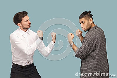 profile side view of two angry boxer businessman, looking to each other with serious face and ready to attack. crisis and partner Stock Photo