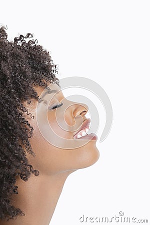 Profile view of an African American woman smiling with eyes closed against gray background Stock Photo