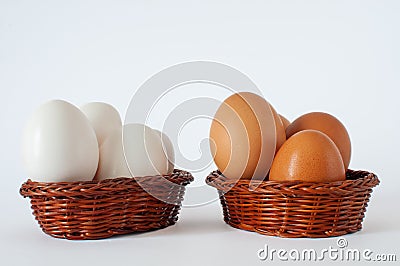 Profile view of brown and white color chicken eggs in mini baskets. Stock Photo