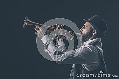Profile view of a jazz trumpet player with beard and hat Stock Photo