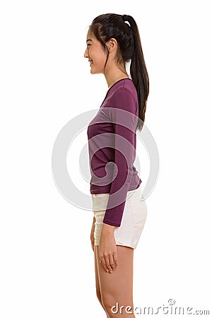 Profile view of young happy Asian teenage girl smiling Stock Photo