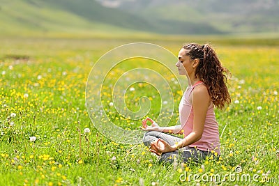 Profile of a yogi doing yoga in mountain field Stock Photo