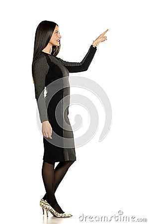 Profile of young beautiful advertizing woman in a short tight dress Stock Photo
