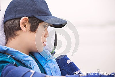 Profile of young disabled boy in wheelchair on misty beach Stock Photo