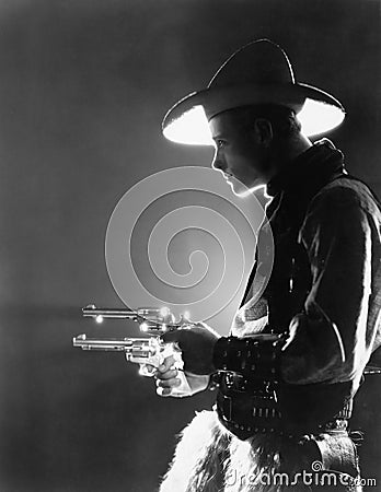 Profile of a young man holding guns Stock Photo