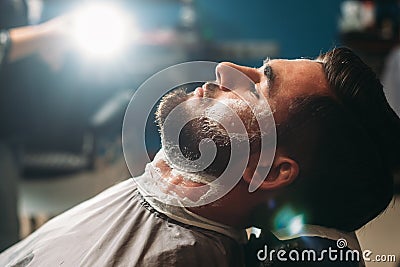 Profile of young man sitting at barbershop Stock Photo