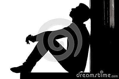 Profile of a young pensive man sitting on the floor and looking up with hope and despair, guy in depression on white back Stock Photo