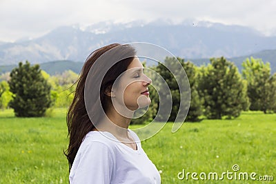 Profile of young woman with eyes closed breathing fresh air in the mountains Stock Photo