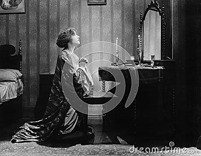 Profile of a young woman pleading in front of a mirror in her bed room Stock Photo