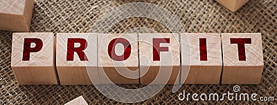 Profit text written on wooden block on burlap canvas background. Business profitability concept Stock Photo