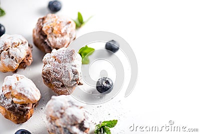 Profiterole or cream puff with filling, powdered sugar topping with berries, isolated on white background Stock Photo