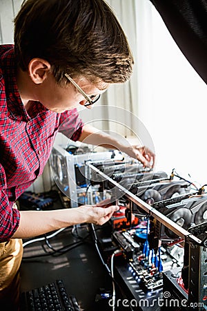 Programmer configures hardware for bitcoin mining Stock Photo