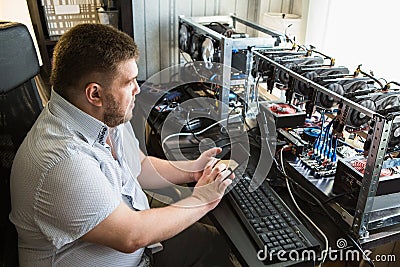 Programmer configures hardware for bitcoin mining Stock Photo