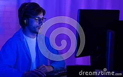 Programmer In Eyeglasses Coding On PC At Home, Low Light Stock Photo