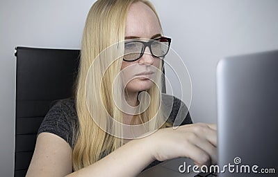 The programmer girl`s glasses reflect moving lines of code. Programming, development of applications, sites and more. Software Stock Photo
