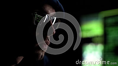 Programmer intently looking at monitor checking data, reflection in glasses Stock Photo