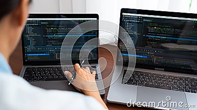 Programmer or software developer Typing New Lines of Code, coding technologies working at wooden industrial interior work place Stock Photo
