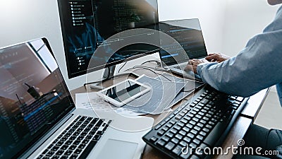 Programmer working On Computer In IT Office Typing Data Coding in software and checking code on computer screen Stock Photo