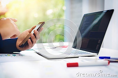 Programmer working test new web design on computer laptop with mobile phone in office. Programming Business Concept Stock Photo