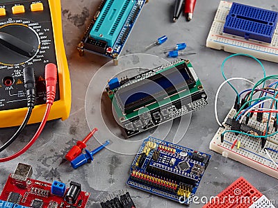 Programmers and Arduino with peripherals and expansion boards lie on a gray background. Do-It-Yourself Stock Photo