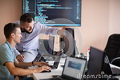 Programmers engrossed in deep collaboration, diligently working together to solve complex problems Stock Photo