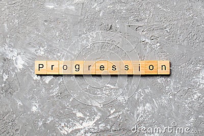 Progression word written on wood block. progression text on cement table for your desing, concept Stock Photo