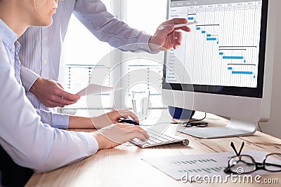 Project management team updating schedule or planning on computer, business Stock Photo