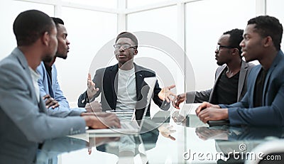 Project Manager explaining something to employees at an office meeting Stock Photo
