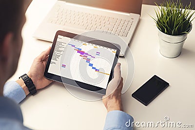 project manager looking at gantt chart on digital tablet Stock Photo