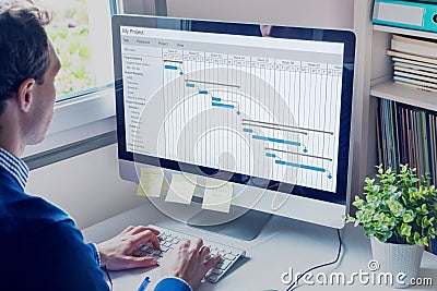 Project manager working on Gantt chart schedule to create planning with tasks and milestones to plan activities, person working Stock Photo