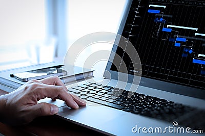 Close up of business man working on laptop computer on wooden de Stock Photo