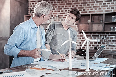 Pensive male engineers sharing experience Stock Photo